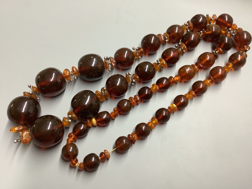 Two single strand reconstituted and natural amber necklaces, both approximately 80 cm, gross weight 172 grams.